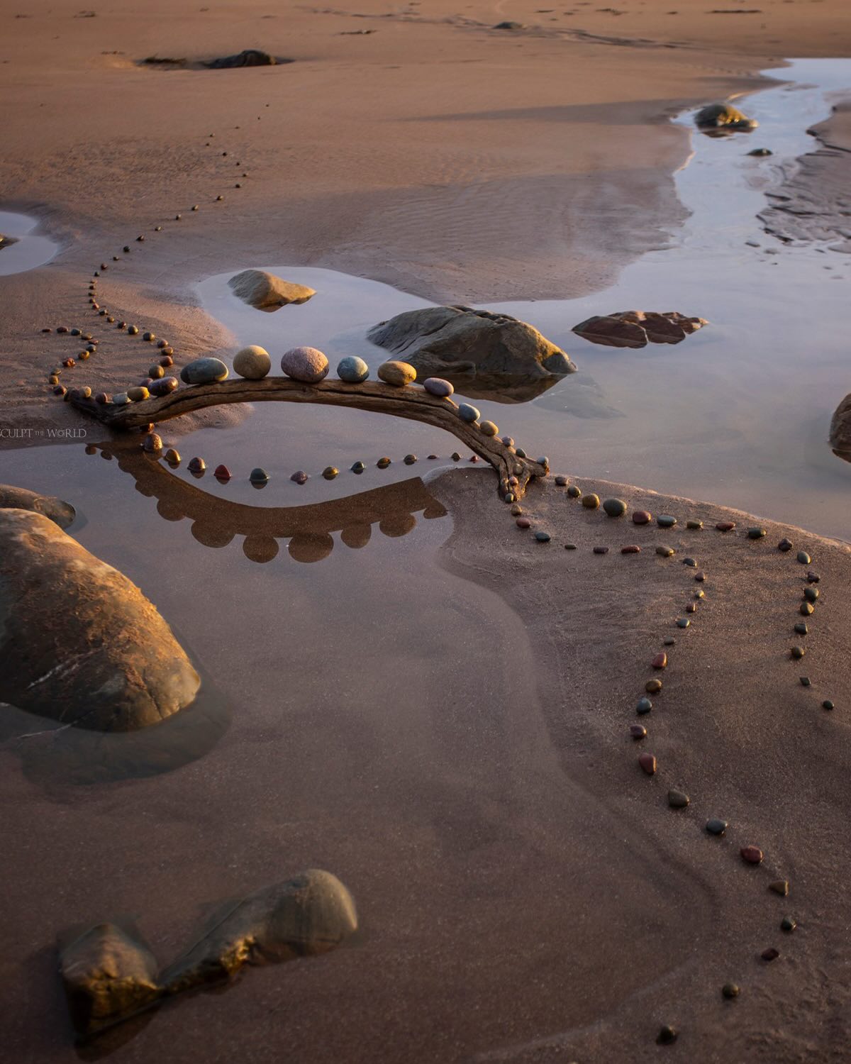Arco de piedras sobre arena de marea