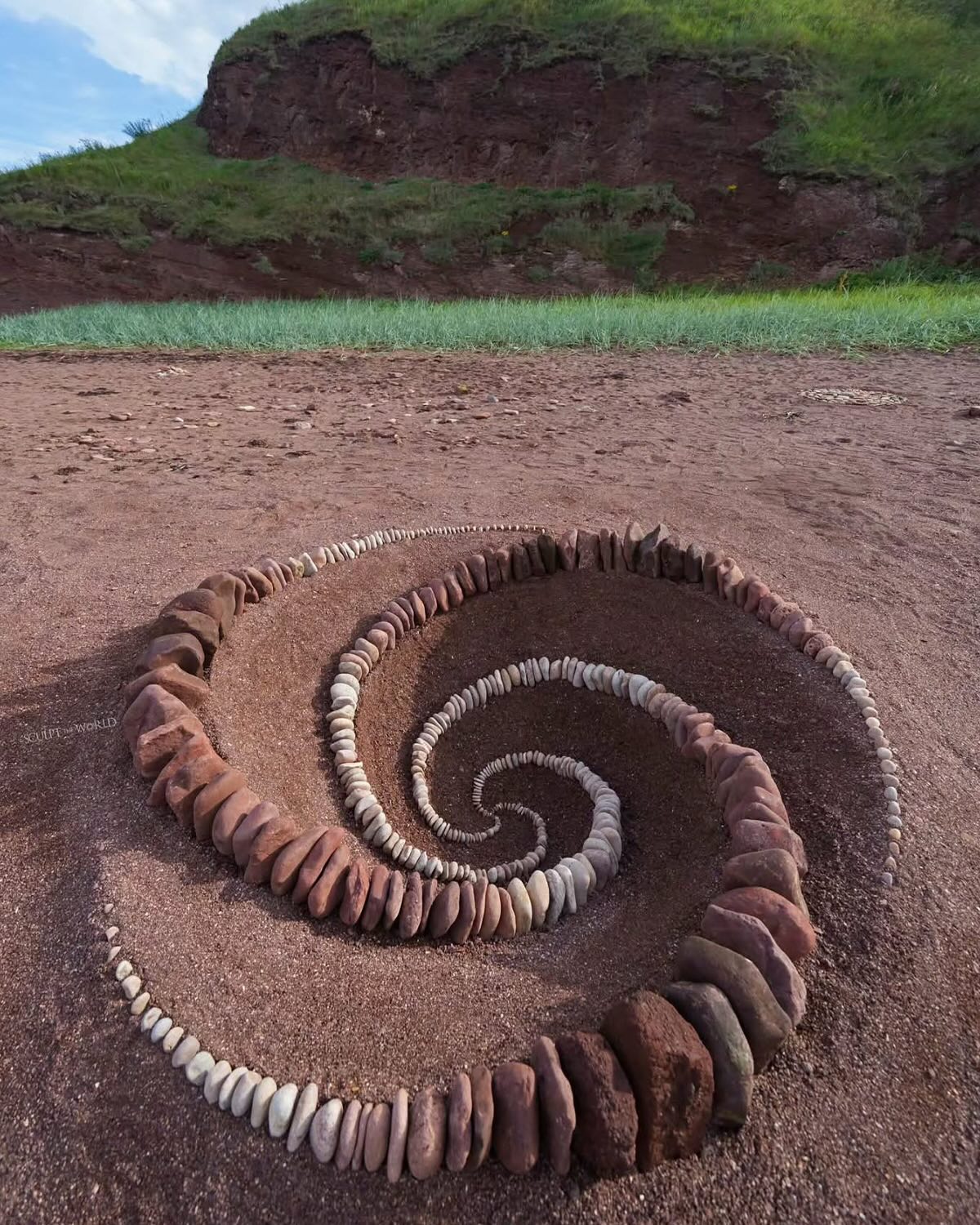 Espiral de piedras sobre tierra roja